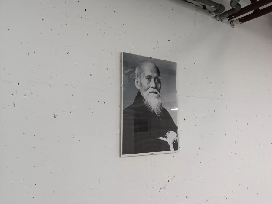 Ein Porträt von Ueshiba Morihei, dem Begründer von Aikido, hängt an der Wand.