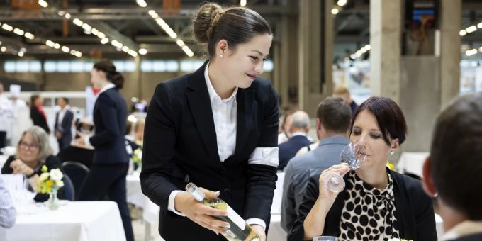 Eine Restaurantfachfrau serviert den Gästen an den diesjährigen SwissSkills einen Weisswein. Swiss Skills