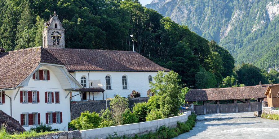 Die evangelisch-reformierte Kirche und das Pfarrhaus am Gsteig 3 in Gsteigwiler. Vorne die Lütschine.