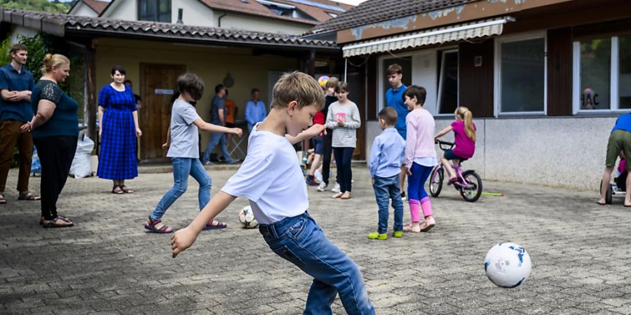 Aus der Ukraine geflüchtete Kinder spielen im Hof des Hauses in Gilly (VD), in dem sie untergebracht sind. Insgesamt leben dort drei Familien mit 25 Kindern und fünf Erwachsenen. (Archiv)