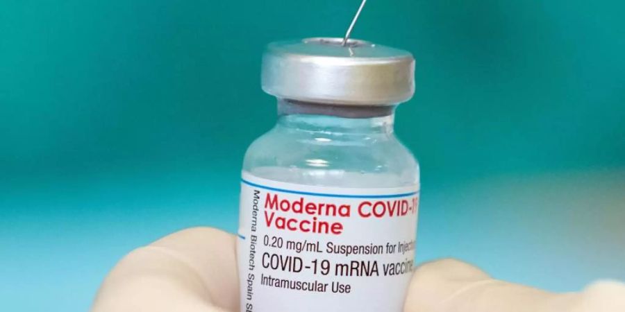 Eine Krankenschwester zieht den Impfstoff des Herstellers Moderna gegen das Coronavirus in einer gestellten Situation mit einer Spritze auf. Foto: Friso Gentsch/dpa