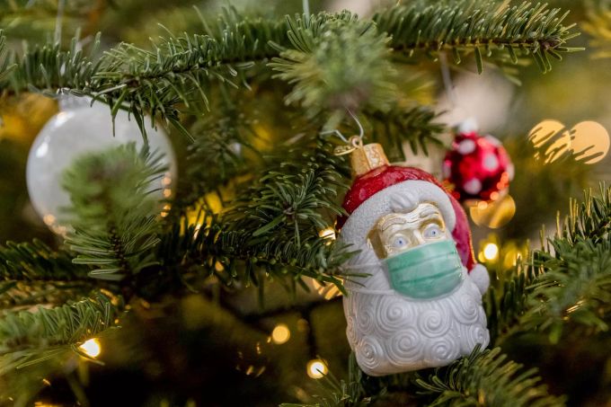 Grosse Corona-Diskussionen sollte man bei der Familienfeier meiden. Kommt es dennoch zu heiklen Situationen, ist die Regel: Klappe halten und lieber in die Küche gehen und Abwasch machen. Weihnachtsmann mit Maske als Schmuck am Weihnachtsbaum