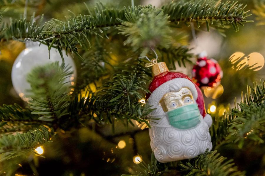 Weihnachtsmann mit Maske als Schmuck am Weihnachtsbaum