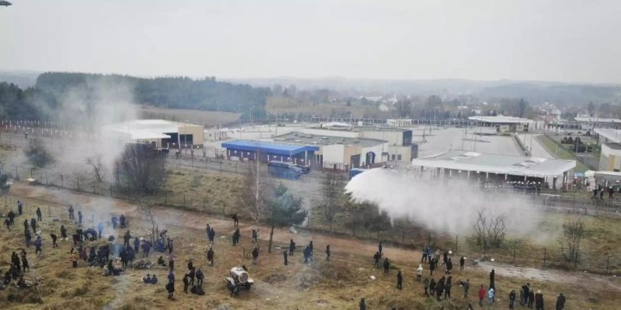 Polnische Grenzsoldaten setzen Wasserwerfer gegen Migranten ein. Foto: Leonid Shcheglov/BelTA/AP/dpa