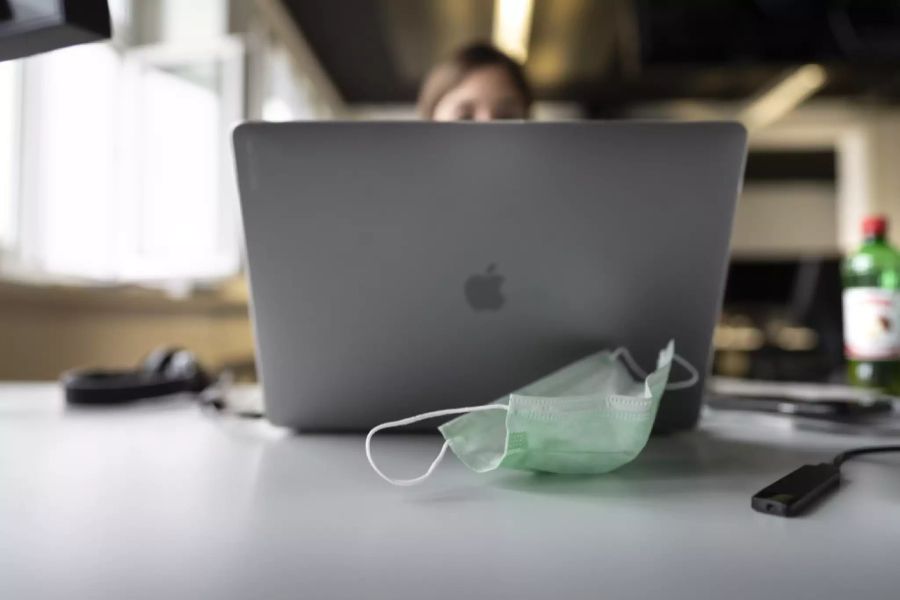 Eine Frau arbeitet am Arbeitsplatz im Buero am Laptop, ihre Schutzmaske liegt auf dem Tisch, fotografiert am 14. Januar 2021 in Zürich.