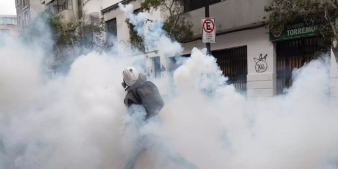Ein Demonstrant wirft einen Tränengaskanister zurück, der von der Polizei abgefeuert wurde, um einen Protest in Santiago aufzulösen. Foto: Matias Basualdo/ZUMA Press Wire/dpa Ein Demonstrant wirft einen Tränengaskanister zurück, der von der Polizei abgefeuert wurde, um einen Protest in Santiago aufzulösen. Foto: Matias Basualdo/ZUMA Press Wire/dpa