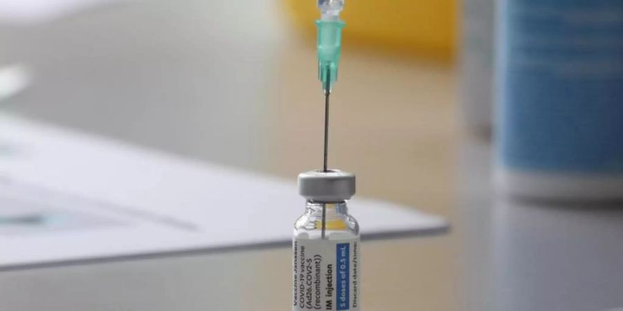 Eine Ampulle mit dem Covid-19-Impfstoff von Johnson & Johnson steht auf einem Tisch. Foto: Bodo Schackow/dpa-Zentralbild/dpa