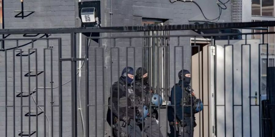 Polizeibeamte vor einem Gebäude in einem Gewerbegebiet in Berlin-Weissensee. Seit dem frühen Morgen wird gegen die Hells Angels in Berlin und Brandenburg vorgegangen. Foto: Paul Zinken/dpa