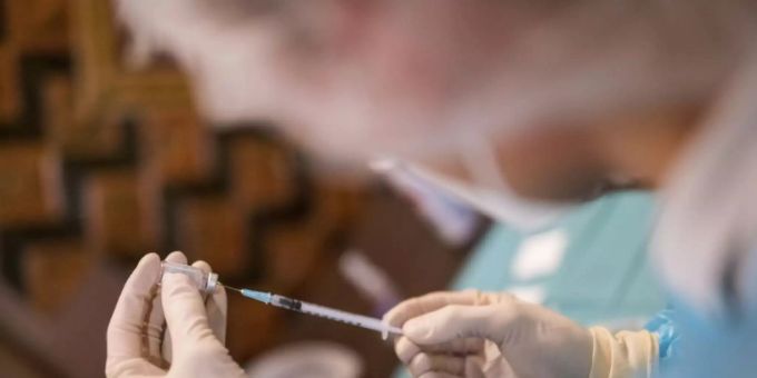 Mediziner füllt Spritze mit Corona-Impfstoff Mediziner füllt Spritze mit Corona-Impfstoff