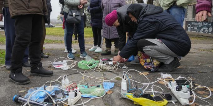 Menschen laden ihre Handys in der Ukraine. Ukraine Krieg