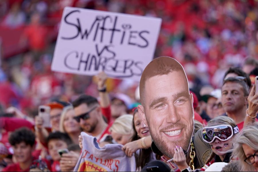 Fans halten ein Schild hoch in Anspielung auf den Tight End der Kansas City Chiefs, Travis Kelce, und Taylor Swift, vor dem Spiel der Chiefs gegen die Los Angeles Chargers, am 22 Oktober 2023, in Kansas City, Missouri.