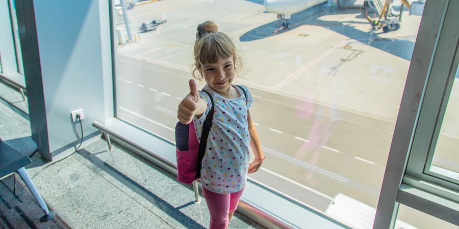 kind am flughafen streckt daumen raus