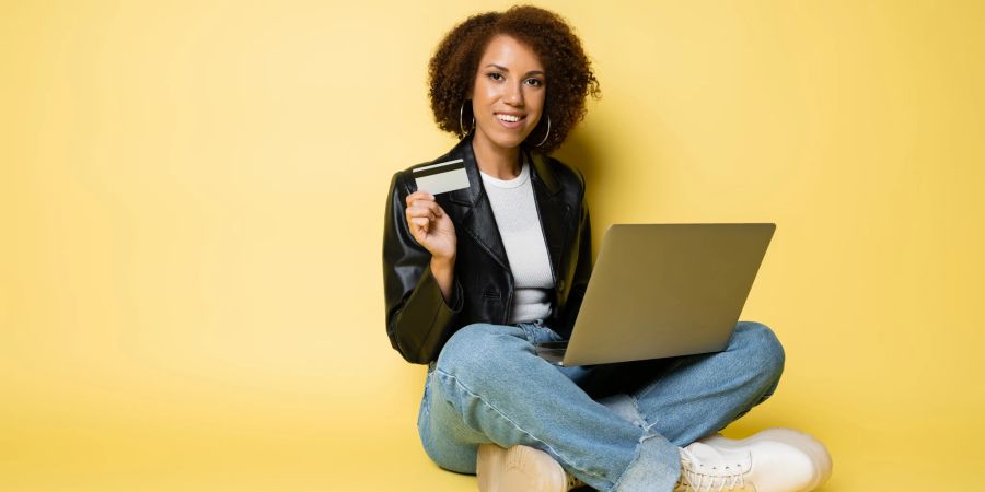 Frau mit Laptop und Geldkarte