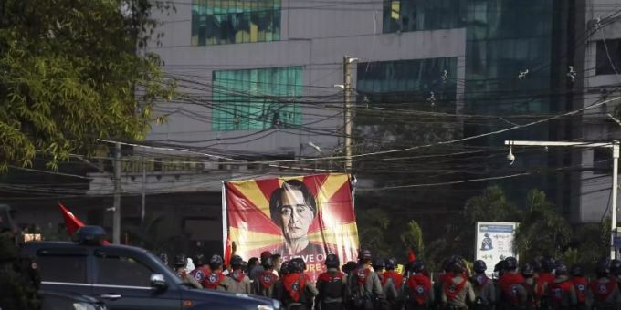Polizisten stehen in Rangun vor Teilnehmern eines Protestes gegen den jüngsten Militärputsch. Auf einem grossen Transparent: das Bild der Regierungschefin Suu Kyi. Foto: Uncredited/AP/dpa Polizisten stehen in Rangun vor Teilnehmern eines Protestes gegen den jüngsten Militärputsch. Auf einem grossen Transparent: das Bild der Regierungschefin Suu Kyi. Foto: Uncredited/AP/dpa