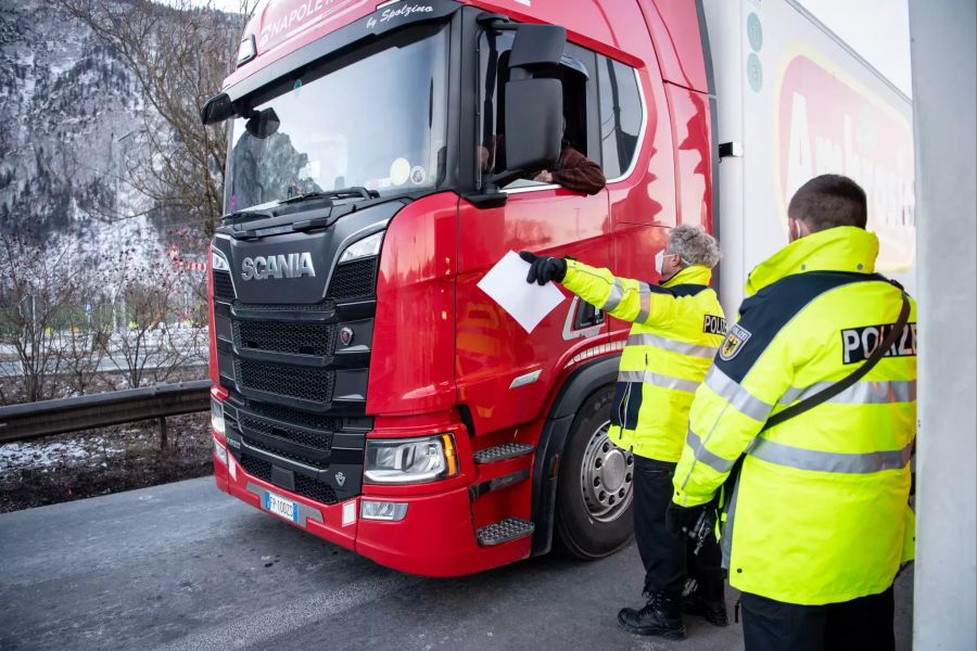 Zwei Bundespolizisten kontrollieren die Dokumente von aus Österreich kommenden LKW-Fahrern an der Autobahn A93 bei Kiefersfelden in Richtung Deutschland. Foto: Matthias Balk