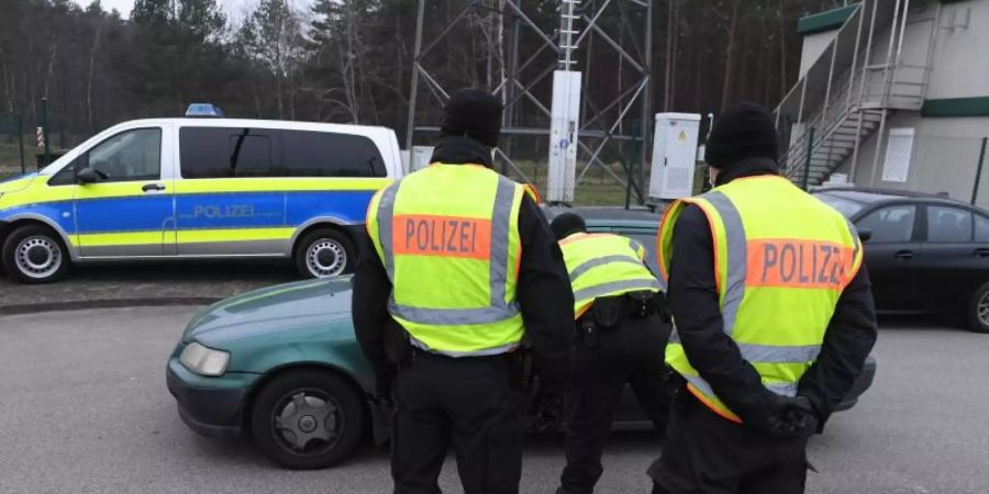 Polizisten kontrollieren ein Fahrzeug vor einem Grenzübergang nach Polen. Foto: Stefan Sauer/dpa