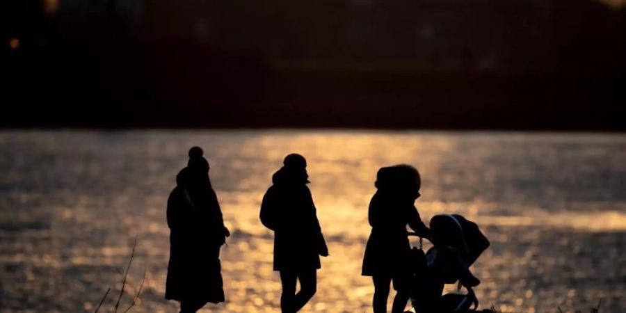 Frische Luft schnappen: Eine Familie ist bei sonnigem Wetter in Hamburg unterwegs. Foto: Daniel Reinhardt/dpa
