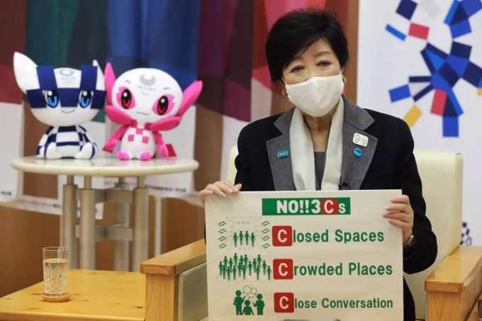 Yuriko Koike, Gouverneurin der Präfektur Tokio, trägt einen Mund-Nasen-Schutz und hebt ein Plakat mit Corona-Regelungen hoch. Die steigende Verfügbarkeit von Corona-Impfstoffen sei ein «Hoffnungsschimmer» für die Ausrichtung der Olympischen Spiele. Foto: Koji Sasahara Coronavirus -Japan