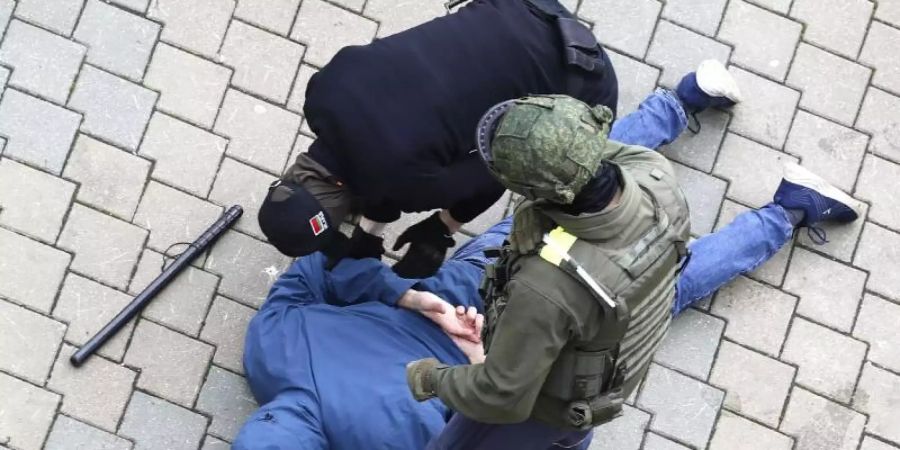 Polizisten nehmen einen am Boden liegenden Mann in Minsk fest. Foto: ---/AP/dpa