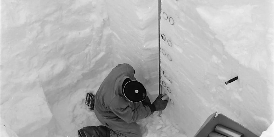 Ein Mitarbeiter des Instituts für Lawinenforschung (SLF) bemisst im Jahr 1953 auf dem Weissfluhjoch in Davos eine Schneedecke. Das SLF warnt seit 75 Jahren in einem Bulletin vor Lawinen. (Archivbild)