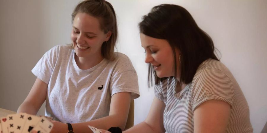 Zwei Frauen spielen Jasskarten.