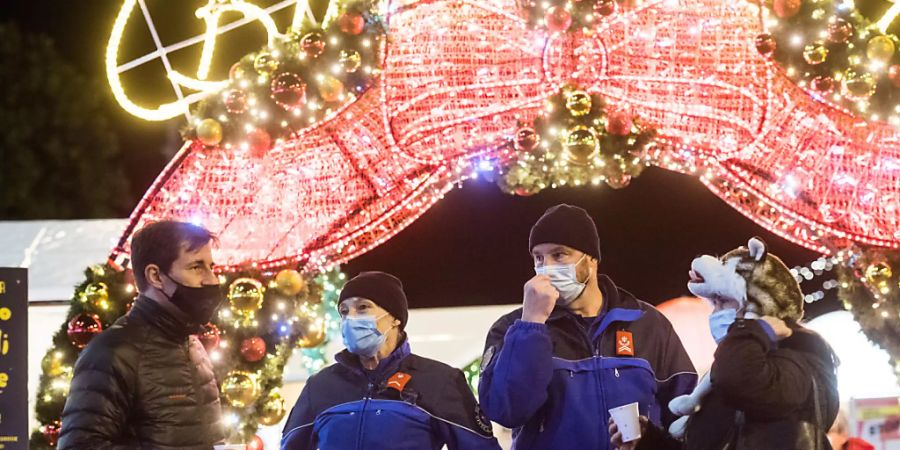 Weihnachten während Zeiten Coronas: Polizisten und Besucher auf dem Weihnachtsmarkt auf der Piazza Riforma in Lugano. (Archivbild)