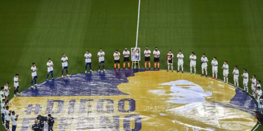 Boca Juniors gegen die Newell's Old Boys: Die Schiedsrichter und die Spieler beider Mannschaften legen vor dem Spiel eine Schweigeminute für den verstorbenen Diego Maradona ein. Foto: Alejandro Pagni/Pool AFP/AP/dpa