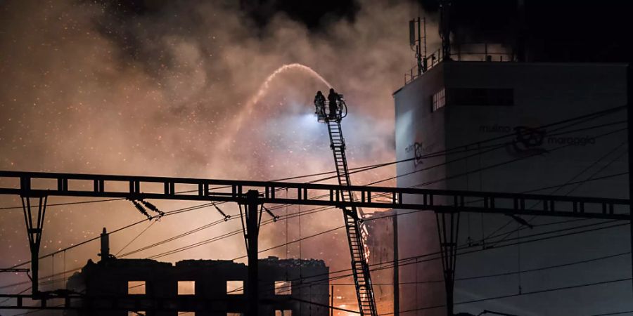 Feuerwehrleute versuchen, den Grossbrand in Maroggia am Luganersee zu löschen.