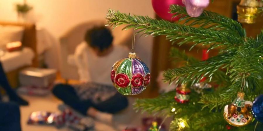 Auch im Corona-Jahr sollen Familien unter einem geschmücktem Weihnachtsbaum gemeinsam Geschenke auspacken können. Foto: Karl-Josef Hildenbrand/dpa