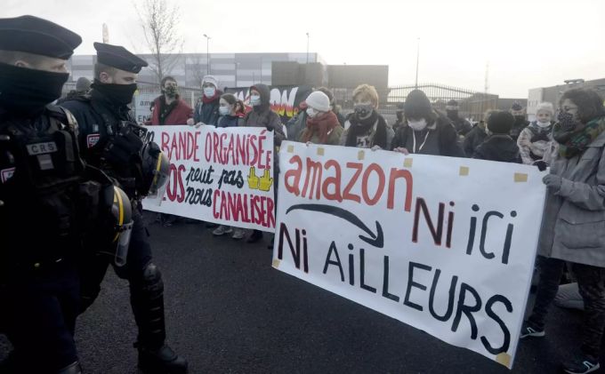 Menschen in Nantes protestieren mit Plakaten mit der Aufschrift «Weder hier noch anderswo» gegen den Internet-Riesen Amazon. Protest nantes amazon