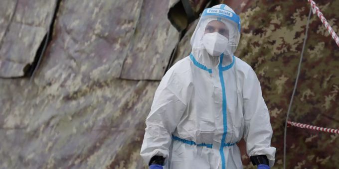 Ein Mitarbeiter des Gesundheitswesens in Schutzanzug arbeitet an einem Kontrollpunkt in Mailand im Kamp gegen das Coronavirus (Archiv). Coronavirus Impfung