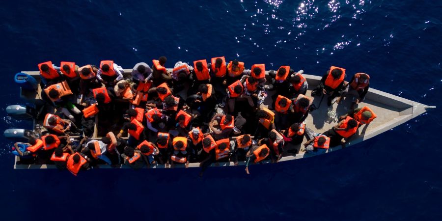 Menschen aus Eritrea, Libyen und dem Sudan warten in einem Holzboot auf die Helfer einer spanischen Nichtregierungsorganisation.