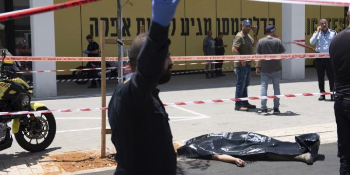 Die Leiche eines palästinensischen Angreifers ist mit einer schwarzen Plastiktüte bedeckt, als er an einer Bushaltestelle in Tel Aviv. Tel Aviv