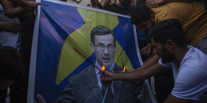Iraker verbrennen das Bild des schwedischen Ministerpräsidenten Ulf Kristersson während einer Demonstration auf dem Tahrir-Platz, Donnerstag, 20. Juli 2023 in Bagdad Irak Sweden