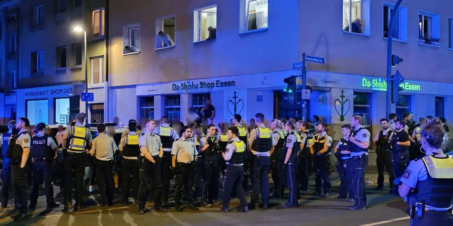 Polizisten bewachen mutmassliche Teilnehmer einer Massenschlägerei in der Essener Innenstadt.