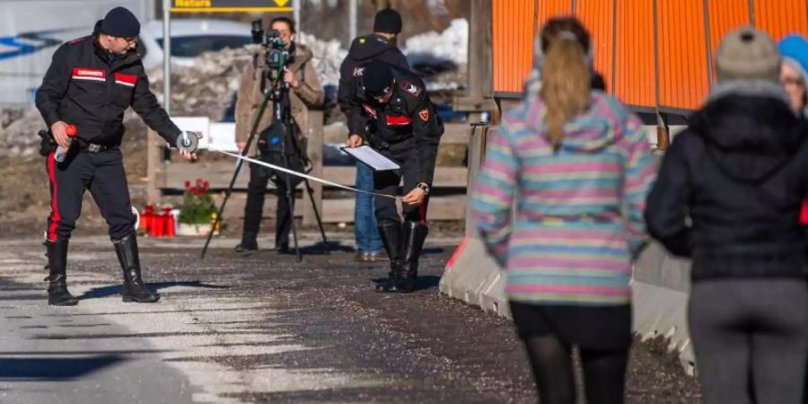 Einsatzkräfte der Carabinieri rekonstruieren in Luttach den Unfallhergang, während Teilnehmer einer Reisegruppe zusehen. Foto: Lino Mirgeler/dpa