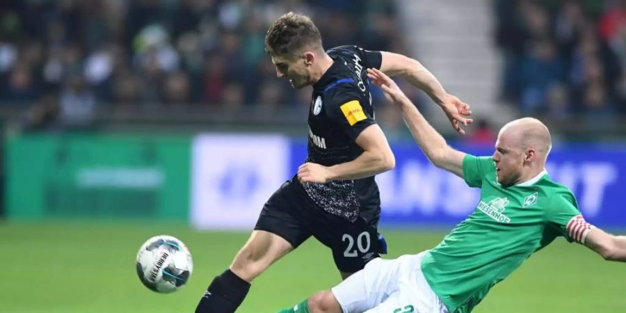 Werders Davy Klaassen (r) will Schalkes Jonjoe Kenny den Ball abnehmen. Foto: Carmen Jaspersen/dpa