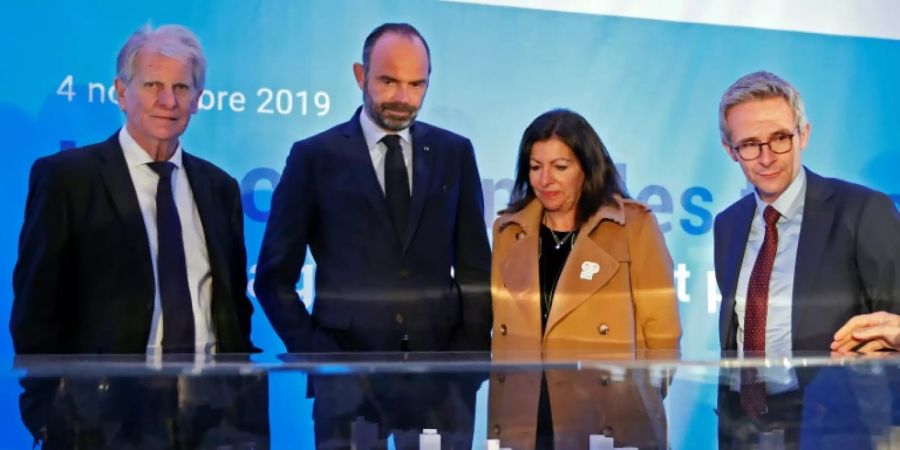 Premierminister Edouard Philippe (2.v.l.) und die Pariser Bürgermeisterin Anne Hidalgo vor einem Modell des Olympia-Dorfs