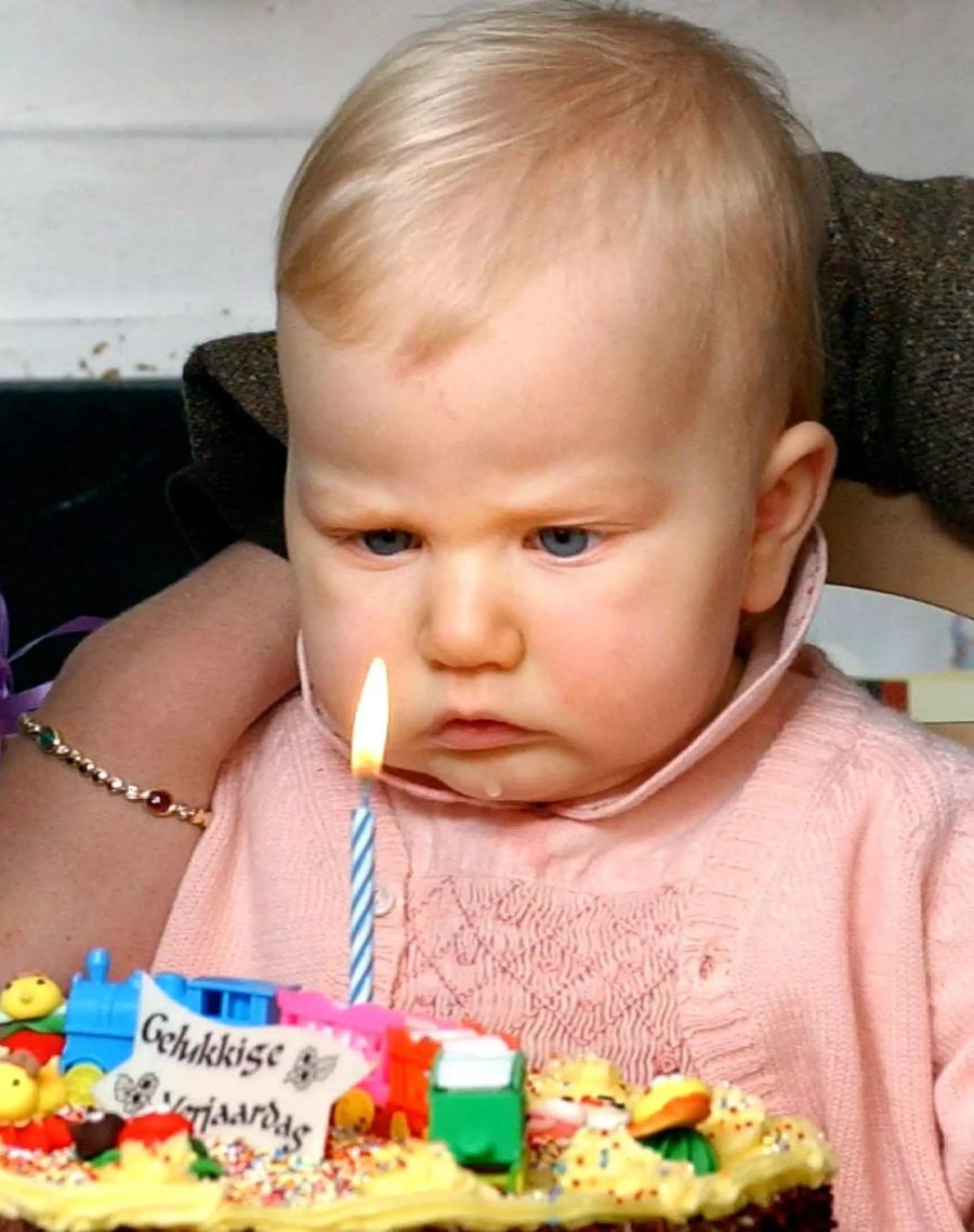 Prinzessin Elisabeth schaut gebannt auf die Kerze auf dem Kuchen zu ihrem ersten Geburtstag.