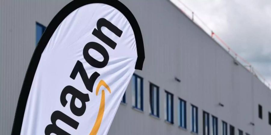 Ein Amazon-Banner vor einem Verteilzentrum des Konzerns. Foto: Martin Schutt/zb/dpa