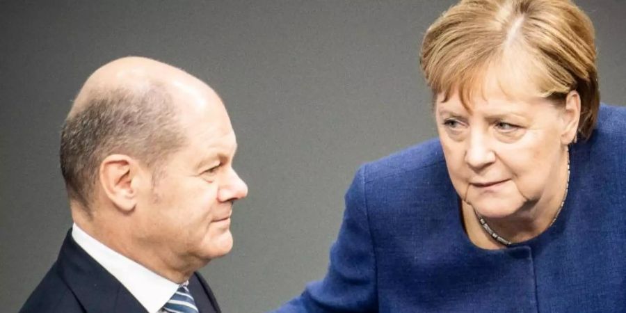 Bundeskanzlerin Angela Merkel (CDU), spricht mit Olaf Scholz (SPD), Bundesfinanzminister, im Bundestag. Foto: Michael Kappeler/dpa