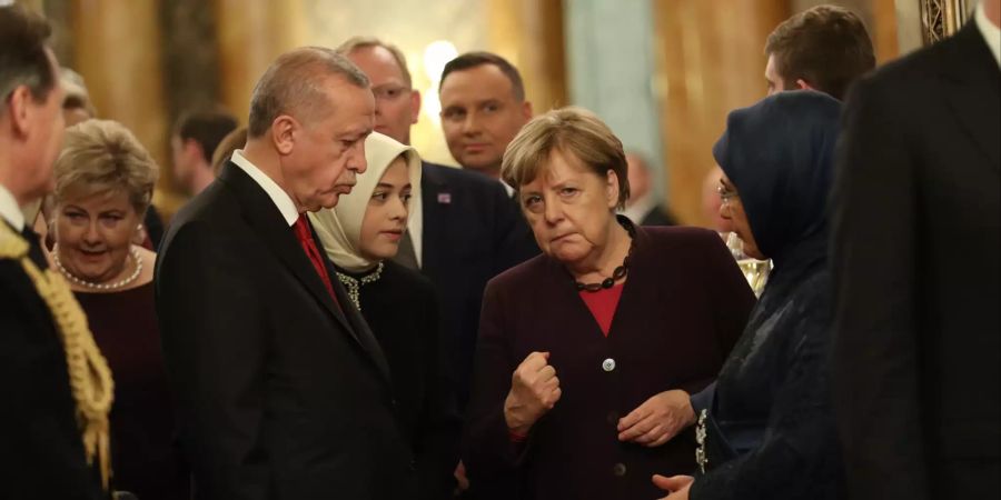 Recep Tayyip Erdogan (l), Staatspräsident der Türkei  und Bundeskanzlerin Angela Merkel (CDU,M) sprechen bei einem Empfang im Buckingham Palace, vor Beginn des eigentlichen Nato-Gipfels.