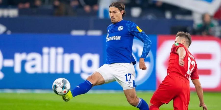 Der Schalker Benjamin Stambouli (l) brach sich den Fuss. Foto: Guido Kirchner/dpa