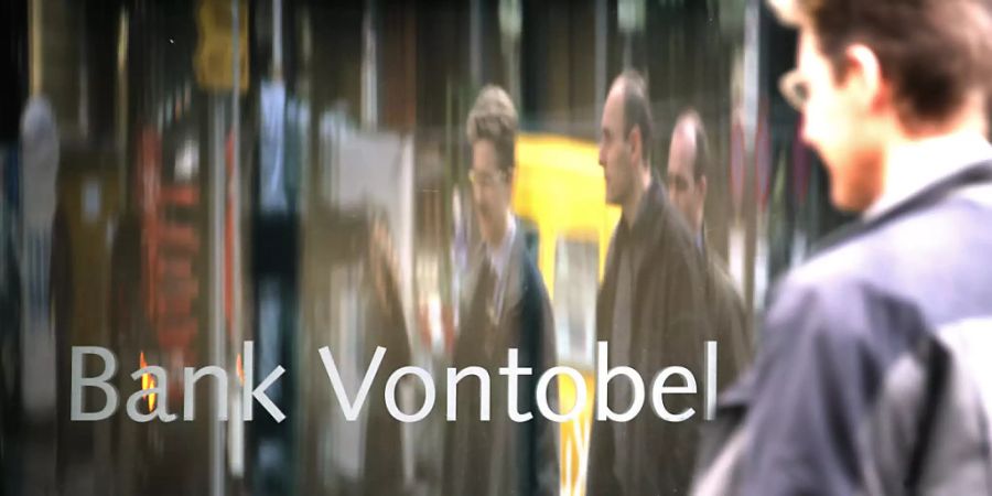 Passanten spiegeln sich in einem Schriftzug vor dem Hauptsitz der Bank Vontobel (Archivbild).