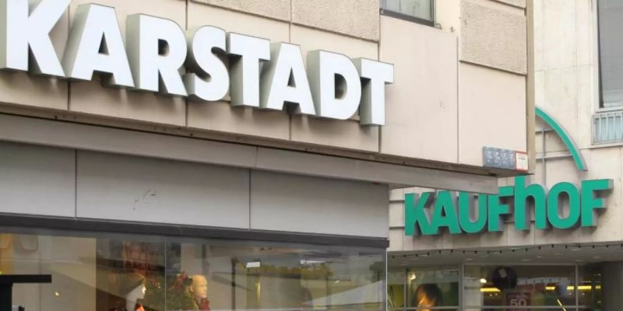 Passaten gehen an Filialen der Warenhausketten Karstadt und Kaufhof vorbei. D. Foto: Birgit Reichert/dpa