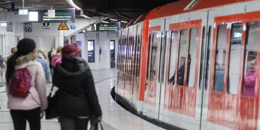 Sehr viel weniger Fahrgäste als üblich stehen auf einem Bahnsteig der S-Bahn Jungfernstieg in Hamburgs Innenstadt. Foto: Markus Scholz/dpa