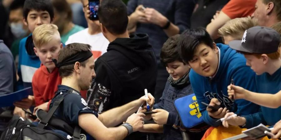Interviews und Autogramme geben sollten Sportler nach Wettkämpfen meiden, rät ein Sportmediziner: Timo Boll mit Fans. Foto: Swen Pförtner/dpa
