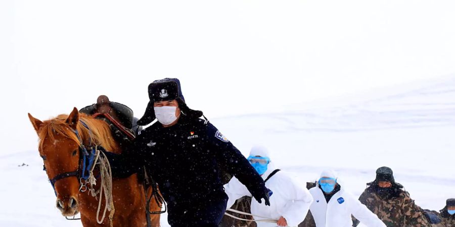 Chinesische Grenzsoldaten versuchen abgelegene Bergdörfer in China über das neuartige Coronavirus zu informieren. (Foto: A RAN/EPA Keystone-SDA)