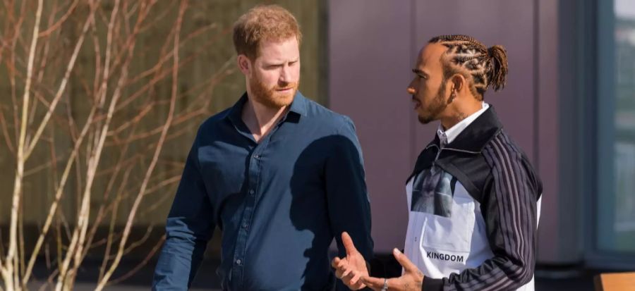 Die Haare sind zusammengebunden: Lewis Hamilton (r.) im Gespräch mit Prinz Harry.