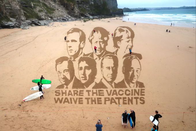 HANDOUT - 11.06.2021, Grossbritannien, Cornwall: Undatierte Aufnahme - Ein grosses Bild im Sand mit Gesichtern den G7- Staats- und Regierungschefs mit dem Schriftzug «Share the Vaccines Wave the Patents» ensteht an einem Strand in Cornwall. G7-Gipfel in Carbis Bay